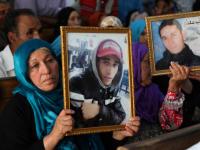 Des familles de victimes de la révolution tunisienne montrent des photos de leurs proches à l’intérieur du palais de justice de Kasserine lors d’un procès organisé par l’Instance vérité et dignité, le 13 juillet 2018 (AFP)